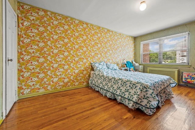 70-40 Utopia Pkwy, Fresh Meadows, NY 11365 - bedroom featuring wallpapered walls, wood finished floors, and radiator