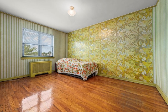 70-40 Utopia Pkwy, Fresh Meadows, NY 11365 - bedroom featuring wood finished floors, radiator heating unit, and wallpapered walls