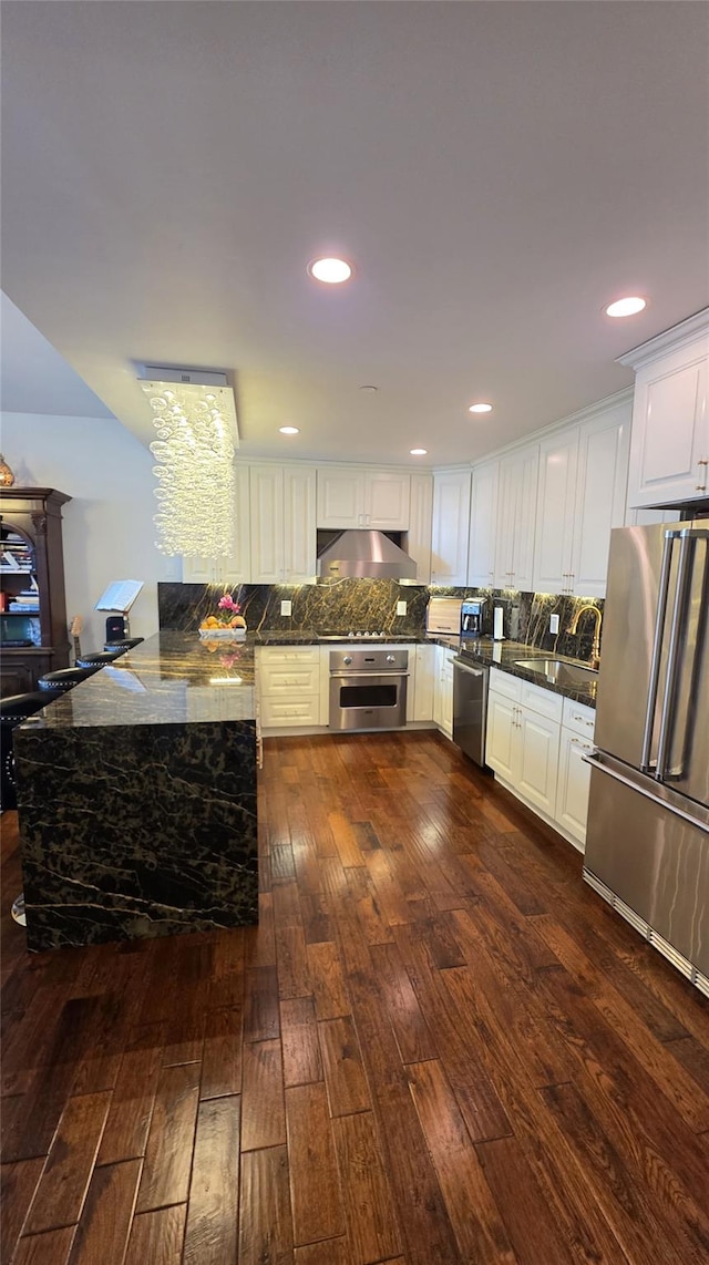 4260 Crescent St Unit 10C, Long Island City, NY 11101 - kitchen featuring dark wood-type flooring, stainless steel appliances, backsplash, white cabinetry, and under cabinet range hood