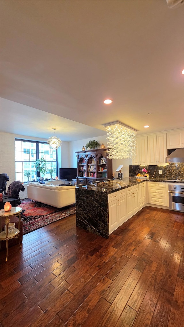 4260 Crescent St Unit 10C, Long Island City, NY 11101 - kitchen featuring dark wood finished floors, oven, open floor plan, dark stone countertops, and a chandelier