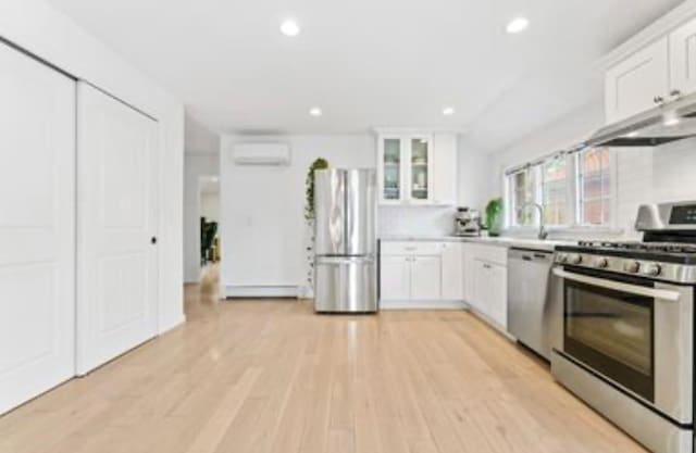 39-12 215th Pl, Bayside, NY 11362 - kitchen featuring appliances with stainless steel finishes, white cabinetry, glass insert cabinets, light countertops, and recessed lighting