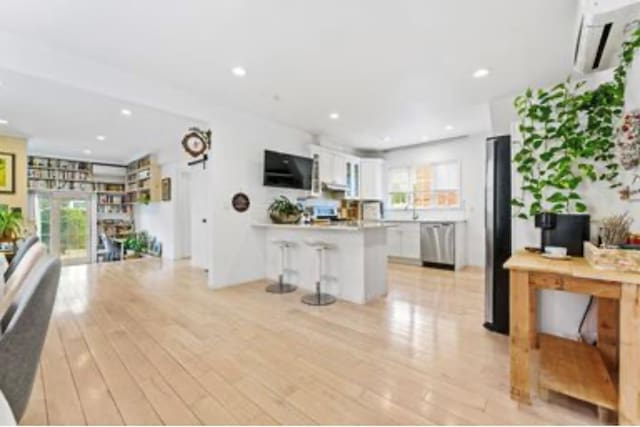 39-12 215th Pl, Bayside, NY 11362 - living area with a wall mounted AC, light wood-style flooring, and recessed lighting
