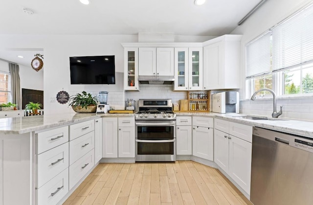 39-12 215th Pl, Bayside, NY 11362 - kitchen with appliances with stainless steel finishes, a peninsula, plenty of natural light, white cabinetry, and recessed lighting