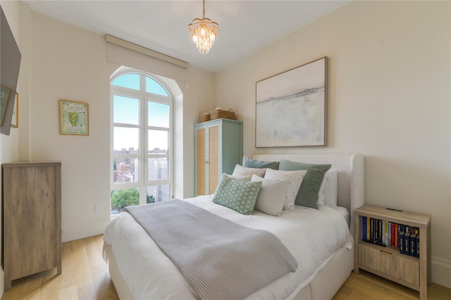 250 E 21st St Unit 9D, New York Manhattan, NY 10010 - bedroom with light wood-style flooring and a chandelier