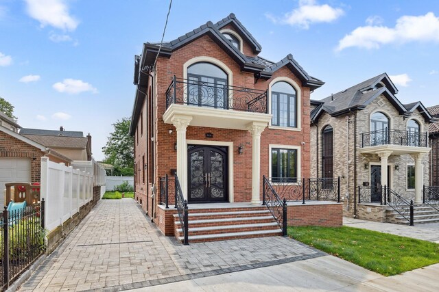 35-26 221st St, Bayside, NY 11361 - french provincial home featuring french doors, a balcony, and brick siding
