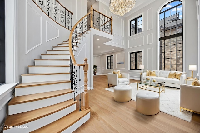35-26 221st St, Bayside, NY 11361 - living area featuring wood finished floors, a high ceiling, stairway, a chandelier, and crown molding