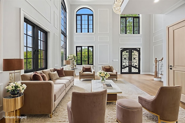 35-26 221st St, Bayside, NY 11361 - living room with french doors, a high ceiling, ornamental molding, wood finished floors, and a chandelier