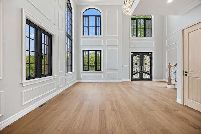 35-26 221st St, Bayside, NY 11361 - entrance foyer with french doors, light wood-type flooring, a chandelier, a high ceiling, and crown molding