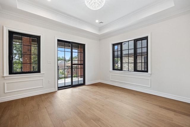 35-26 221st St, Bayside, NY 11361 - spare room with a raised ceiling, crown molding, light wood-style floors, and a chandelier