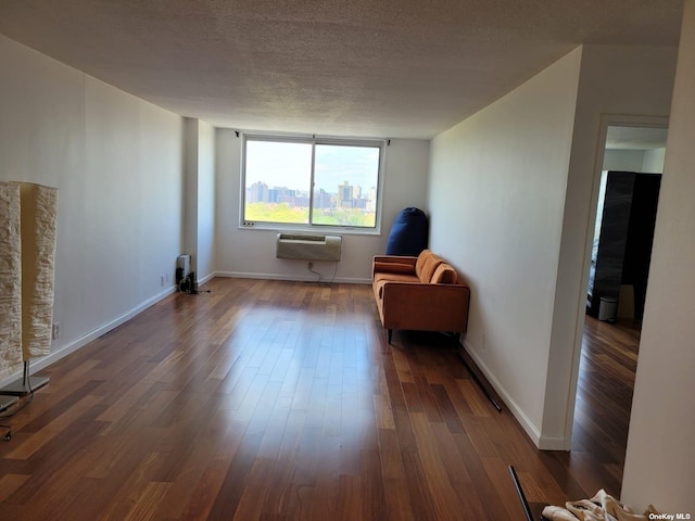 118-17 Union Tpke Unit 14E, Forest Hills, NY 11375 - living area featuring dark wood-style floors, a textured ceiling, and a wall mounted air conditioner