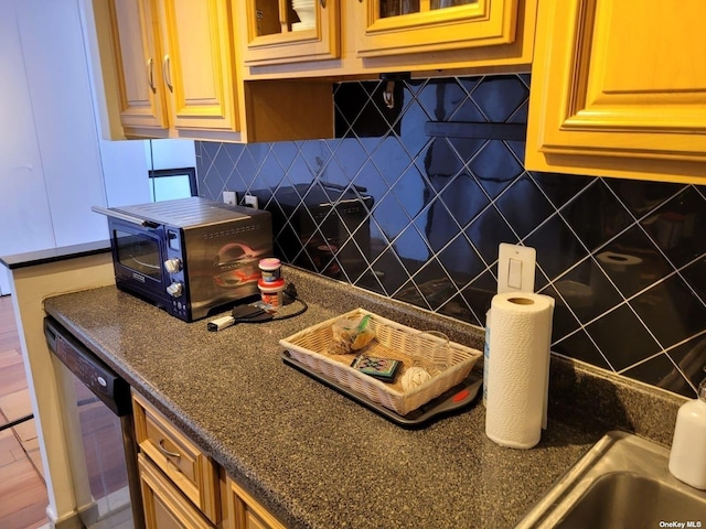 118-17 Union Tpke Unit 14E, Forest Hills, NY 11375 - kitchen with dark countertops, stainless steel dishwasher, tasteful backsplash, and glass insert cabinets