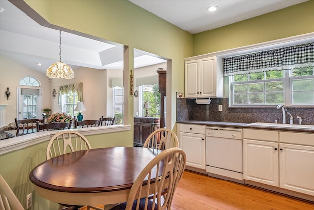 575 Mirror Pond Ct, Moriches, NY 11955 - kitchen featuring white dishwasher, a chandelier, light wood-style flooring, white cabinets, and decorative backsplash
