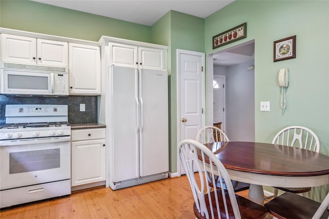 575 Mirror Pond Ct, Moriches, NY 11955 - kitchen featuring white appliances, white cabinets, light wood-type flooring, tasteful backsplash, and dark countertops