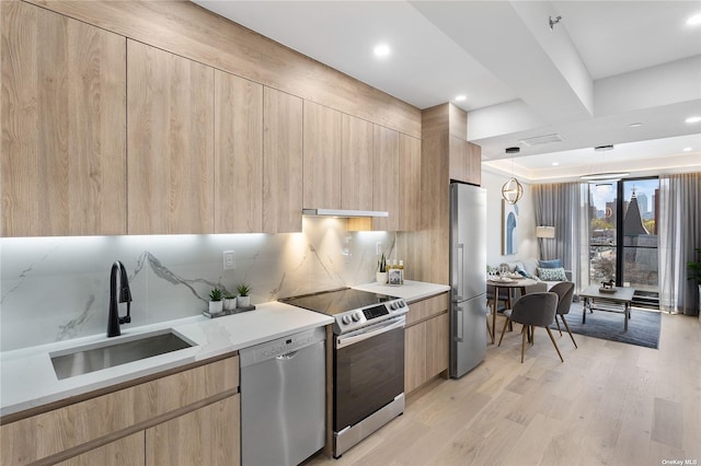 14-54 31st Ave Unit 3A, Astoria, NY 11106 - kitchen with light brown cabinetry, modern cabinets, stainless steel appliances, light wood-style floors, and decorative backsplash