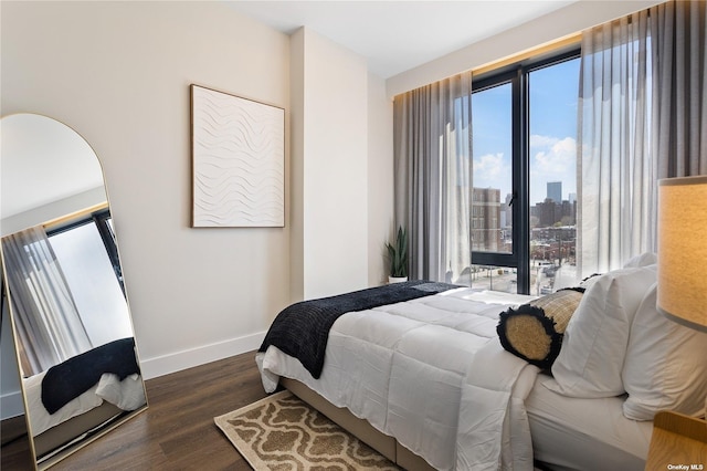 14-54 31st Ave Unit 3A, Astoria, NY 11106 - bedroom with dark wood finished floors, multiple windows, and a view of skyline
