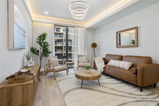 14-54 31st Ave Unit 3A, Astoria, NY 11106 - living area featuring wood finished floors, a chandelier, healthy amount of natural light, and a tray ceiling