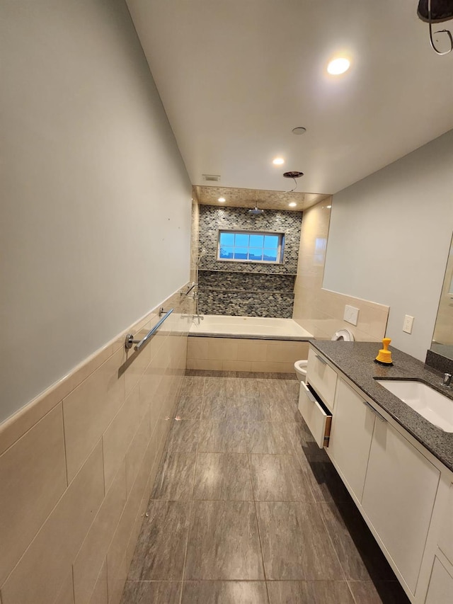 7 E Blvd, East Rockaway, NY 11518 - bathroom featuring vanity, tiled bath, tile walls, tile patterned floors, and recessed lighting