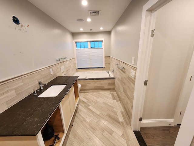 7 E Blvd, East Rockaway, NY 11518 - full bath featuring a bath, wood finished floors, tile walls, recessed lighting, and vanity
