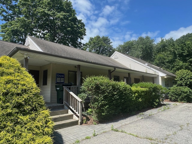 view of front of property with a shingled roof and covered porch