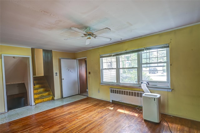 1435 Peters Blvd, Bay Shore, NY 11706 - foyer with a ceiling fan, radiator, wood-type flooring, stairs, and crown molding