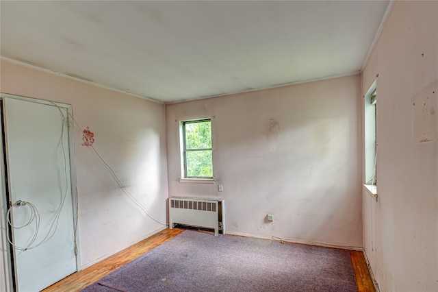 1435 Peters Blvd, Bay Shore, NY 11706 - unfurnished bedroom with radiator heating unit and wood finished floors