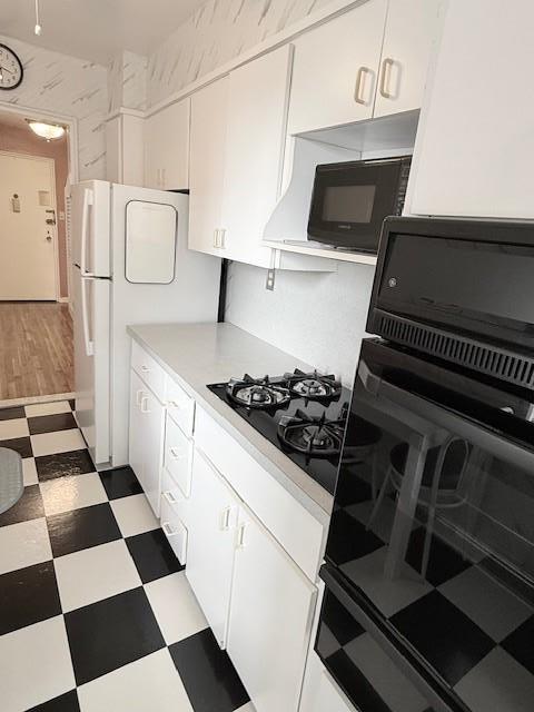 210-15 23rd Ave Unit 4E, Bayside, NY 11360 - kitchen with black appliances, light floors, white cabinets, and light countertops