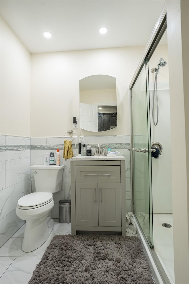 228 Pacific St, Brooklyn, NY 11201 - full bath featuring tile walls, vanity, marble finish floors, wainscoting, and a stall shower