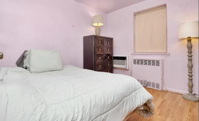 153-25 88th St Unit 1J, Howard Beach, NY 11414 - bedroom with radiator, wood finished floors, and a wall unit AC