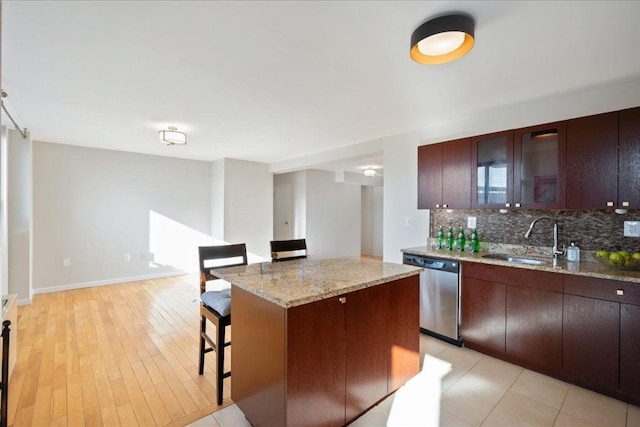 2287 Johnson Ave Unit 3A, Bronx, NY 10463 - kitchen with decorative backsplash, stainless steel dishwasher, a breakfast bar, a center island, and glass insert cabinets