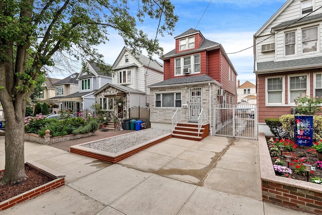 78-33 64th St, Glendale, NY 11385 - view of front of home with a gate, stone siding, roof with shingles, and a residential view