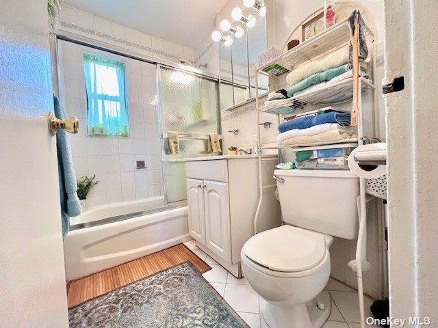 219-36 74th Ave Unit 323A1, Bayside, NY 11364 - bathroom with shower / bath combination with glass door, vanity, and tile patterned flooring