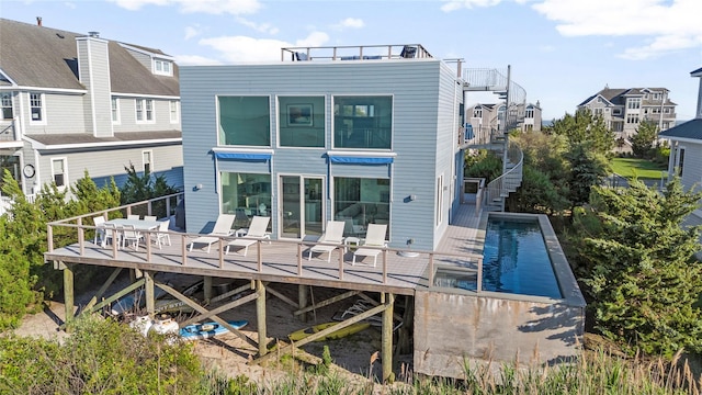 846 Dune Rd, Westhampton Dunes, NY 11978 - back of house featuring stairs, a wooden deck, and an outdoor pool
