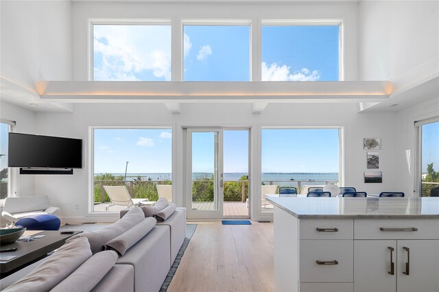 846 Dune Rd, Westhampton Dunes, NY 11978 - living area featuring a towering ceiling, light wood-style flooring, and a water view