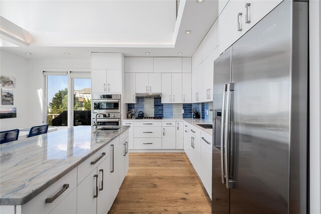 846 Dune Rd, Westhampton Dunes, NY 11978 - kitchen with stainless steel fridge, decorative backsplash, recessed lighting, white cabinets, and light wood-type flooring
