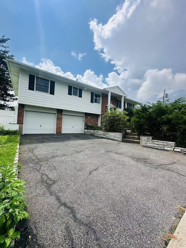 202 Nelson Ct, Syosset, NY 11791 - bi-level home with brick siding, asphalt driveway, and a garage