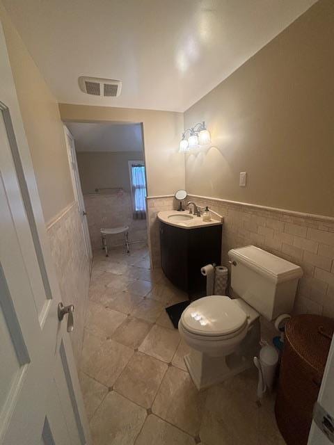 89 Hampton Ave, Albertson, NY 11507 - bathroom with tile walls, a wainscoted wall, vanity, and tile patterned floors