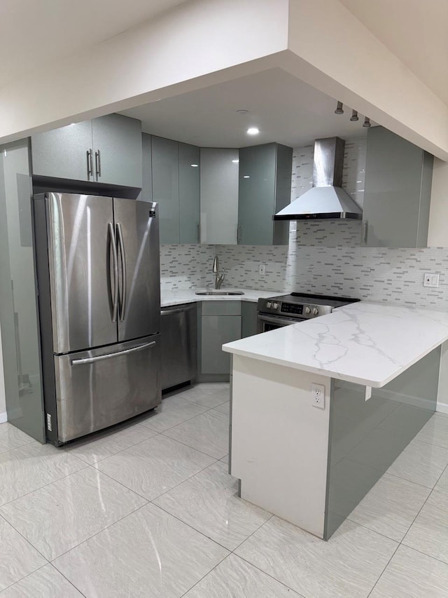 756 40th St Unit 2R, Brooklyn, NY 11232 - kitchen with gray cabinetry, appliances with stainless steel finishes, a peninsula, wall chimney range hood, and backsplash