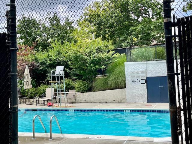23-20 Bell Blvd Unit 2D, Bayside, NY 11360 - community pool with view of scattered trees and a patio area