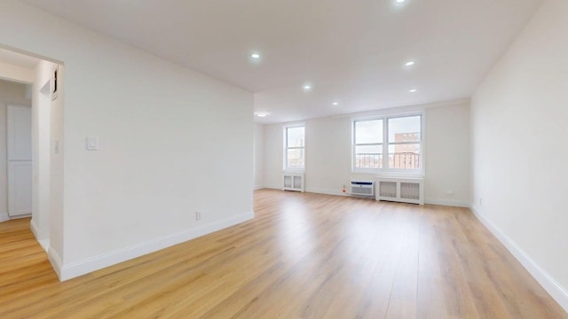 66-15 Thornton Pl Unit 6S, Rego Park, NY 11374 - unfurnished living room featuring light wood-type flooring, radiator, recessed lighting, and a wall mounted AC