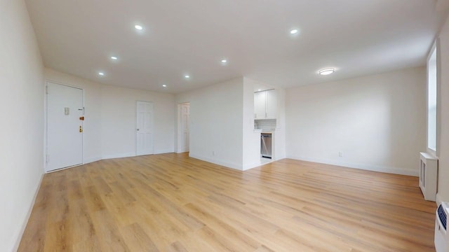 66-15 Thornton Pl Unit 6S, Rego Park, NY 11374 - unfurnished living room featuring light wood-type flooring, recessed lighting, and radiator heating unit