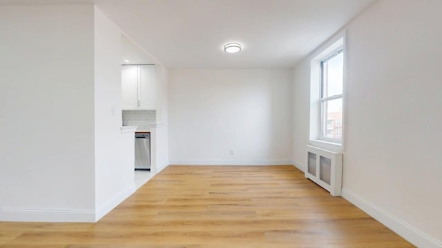 66-15 Thornton Pl Unit 6S, Rego Park, NY 11374 - unfurnished living room with radiator heating unit, light wood-type flooring, and a glass covered fireplace