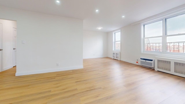 66-15 Thornton Pl Unit 6S, Rego Park, NY 11374 - spare room with light wood-style flooring, radiator heating unit, recessed lighting, and a wall mounted AC