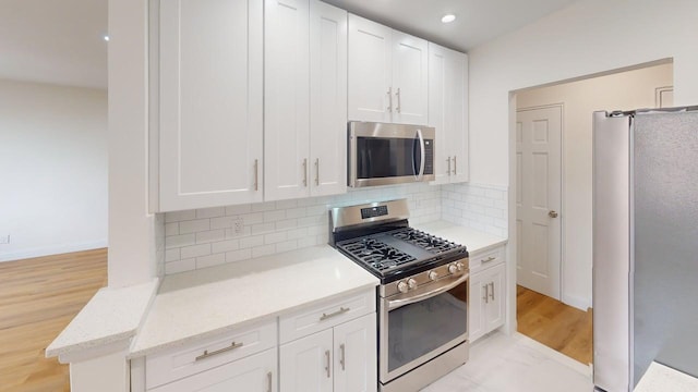 66-15 Thornton Pl Unit 6S, Rego Park, NY 11374 - kitchen with appliances with stainless steel finishes, backsplash, white cabinets, and recessed lighting
