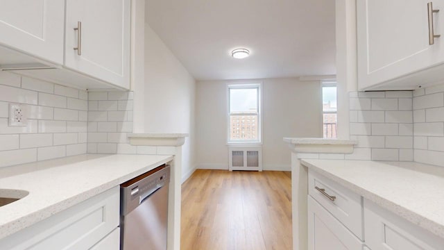 66-15 Thornton Pl Unit 6S, Rego Park, NY 11374 - kitchen featuring backsplash, stainless steel dishwasher, and white cabinetry