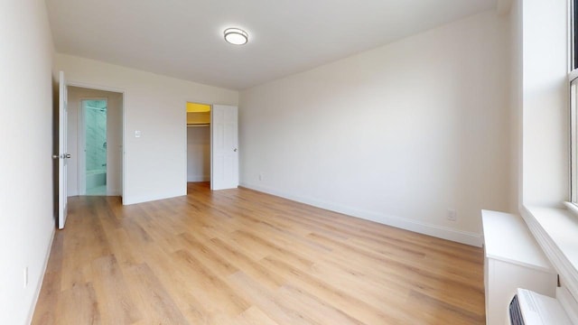 66-15 Thornton Pl Unit 6S, Rego Park, NY 11374 - unfurnished bedroom featuring light wood-type flooring and a walk in closet