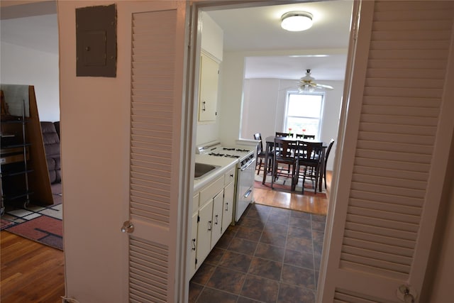 100 S Ocean Ave Unit 4A, Freeport, NY 11520 - kitchen featuring ceiling fan, white cabinets, white gas stove, electric panel, and light countertops
