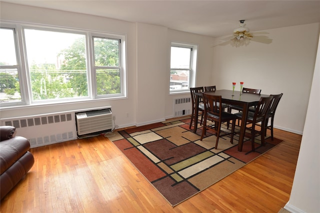 100 S Ocean Ave Unit 4A, Freeport, NY 11520 - dining space featuring radiator, hardwood / wood-style floors, a ceiling fan, and a wall unit AC