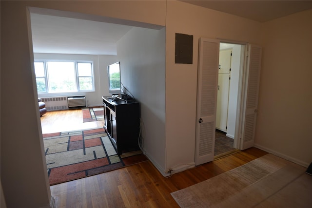 100 S Ocean Ave Unit 4A, Freeport, NY 11520 - corridor with wood finished floors, electric panel, and radiator