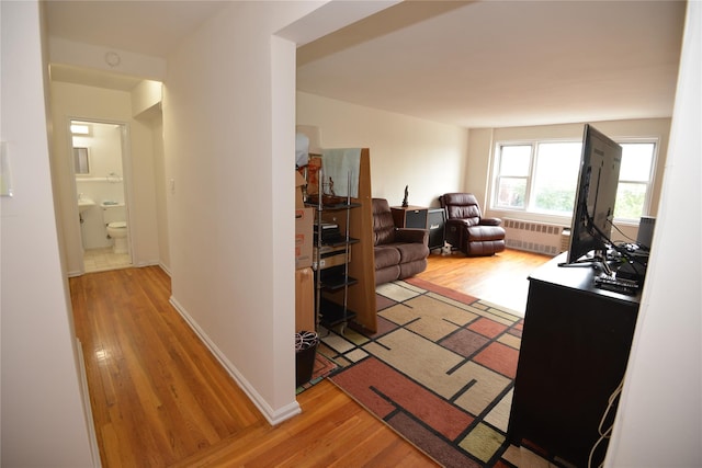 100 S Ocean Ave Unit 4A, Freeport, NY 11520 - hallway featuring light wood-type flooring and radiator heating unit