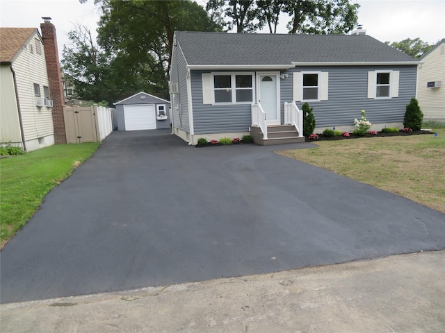 118 Muncy Ave, West Babylon, NY 11704 - single story home featuring asphalt driveway, a garage, an outbuilding, roof with shingles, and a front lawn